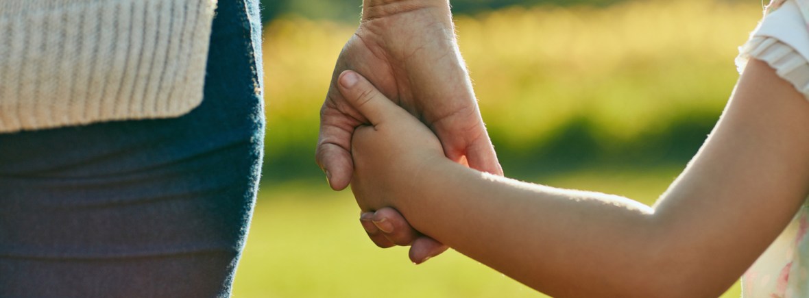 Cropped shot of a little girl holding an unrecognizable woman’s hand in the park