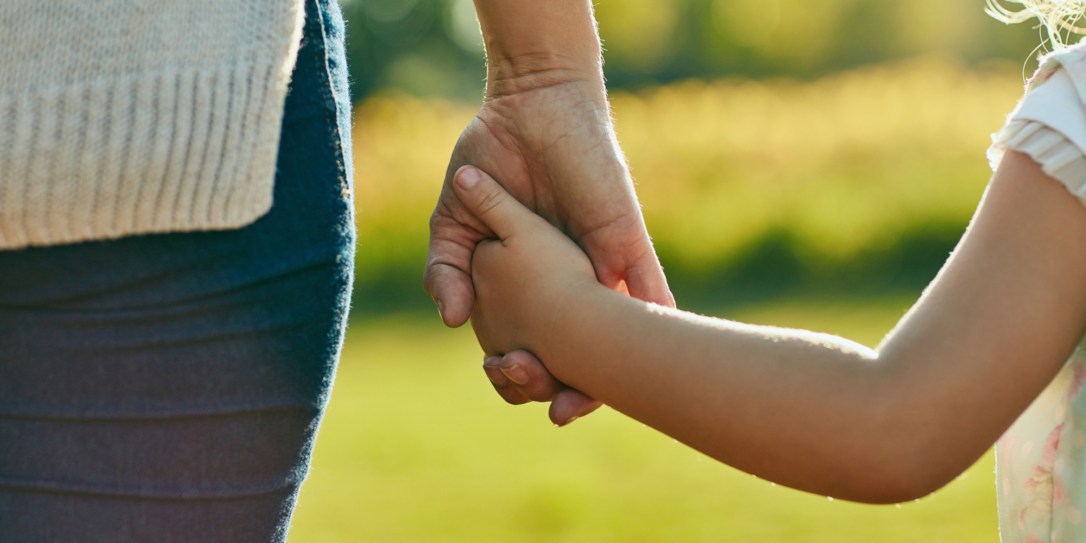 Cropped shot of a little girl holding an unrecognizable woman’s hand in the park